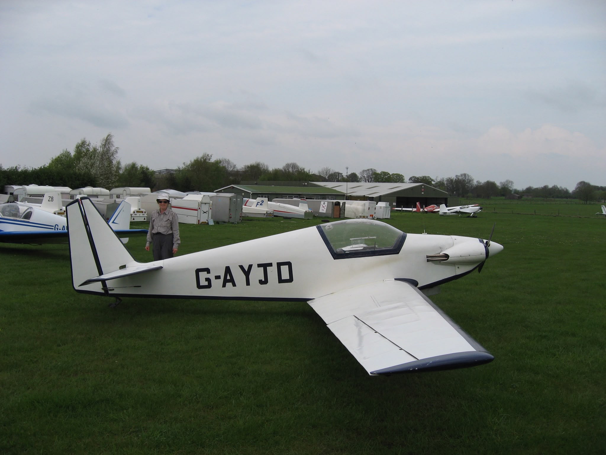 G-AYJD on the grass, owner standing alongside