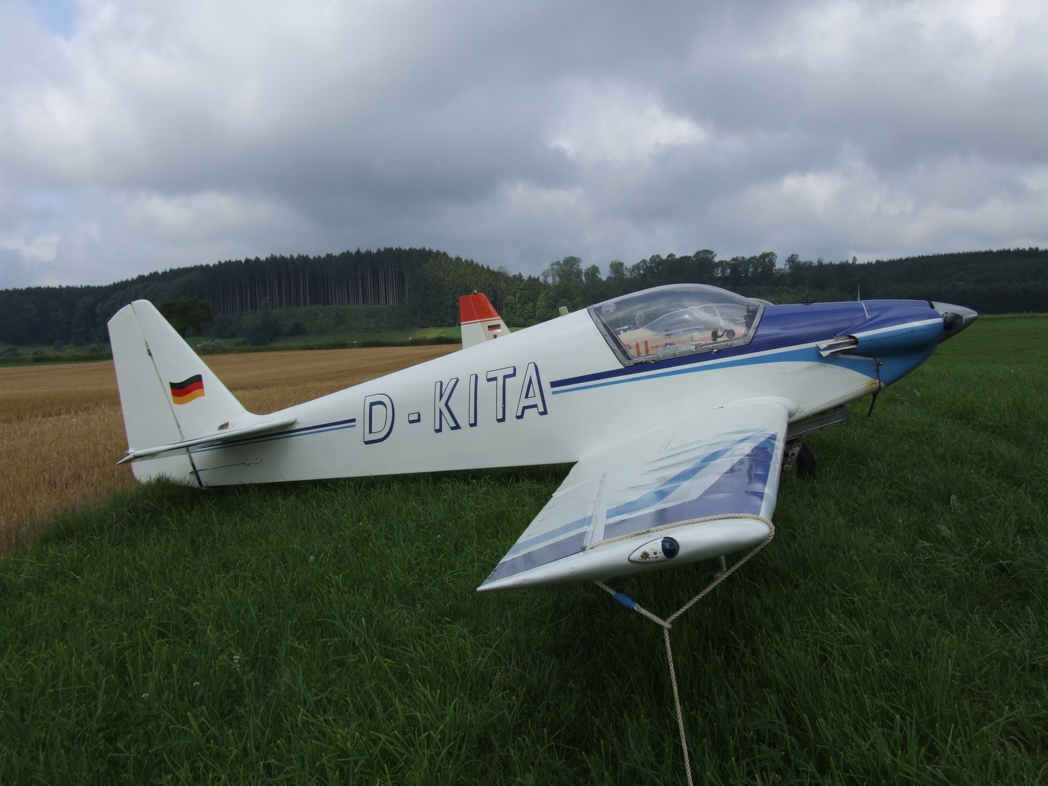 D-KITA, blue and white, tied down on the grass at Tannheim