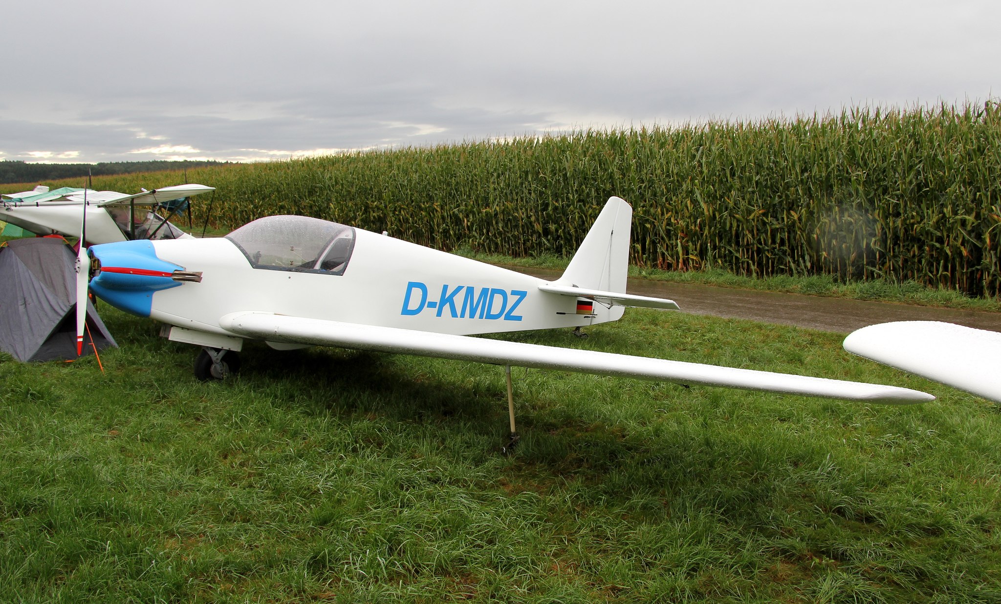 D-KMDZ, white and blue, parked by a cornfield at Tannheim