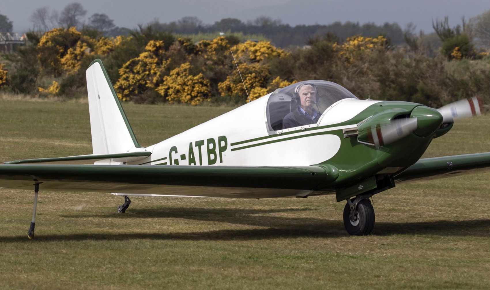 G-ATBP taxiing, green and white, pilot visible in the cockpit
