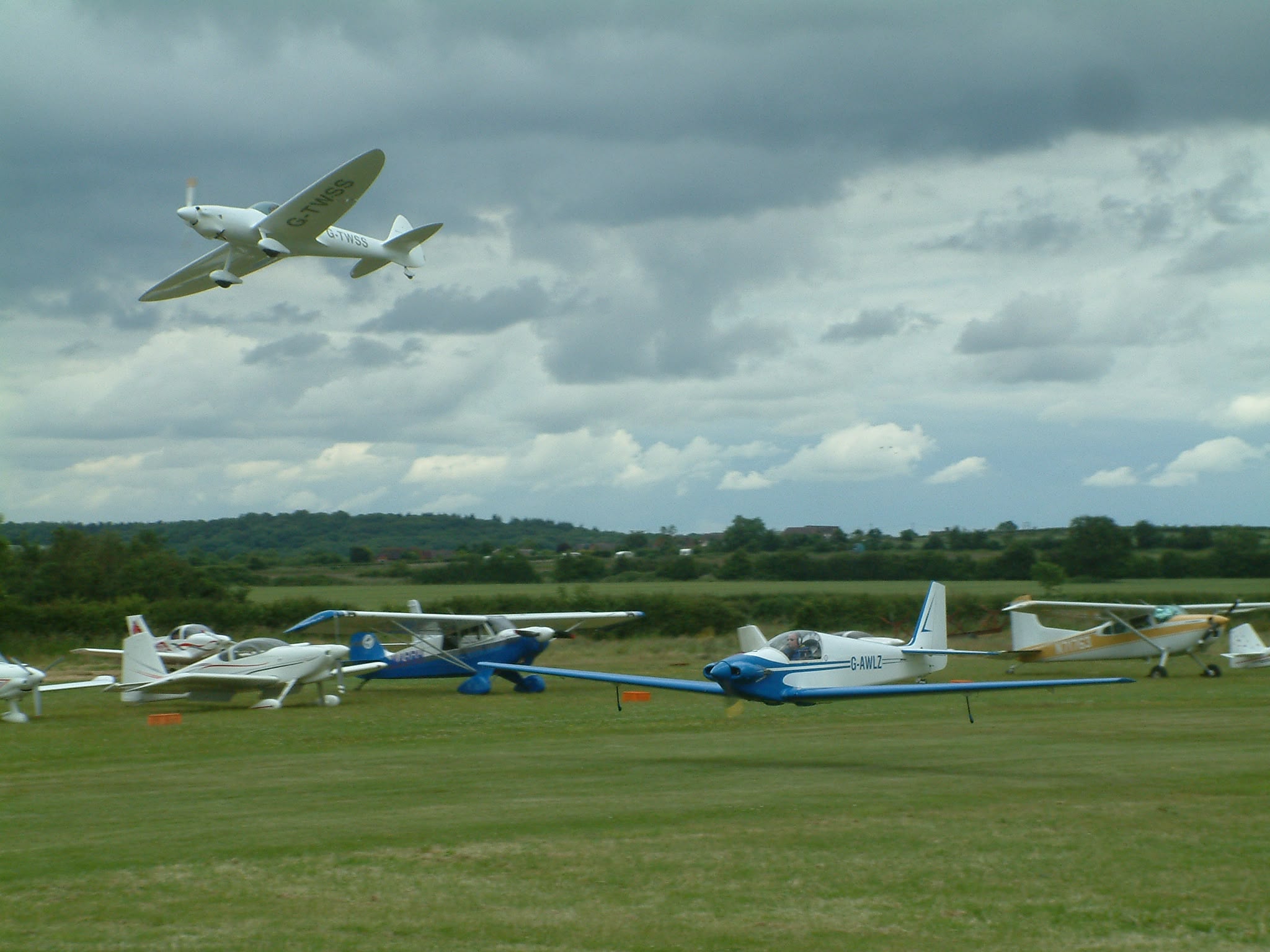 G-AWLZ landing at a fly-in, another aircraft overhead