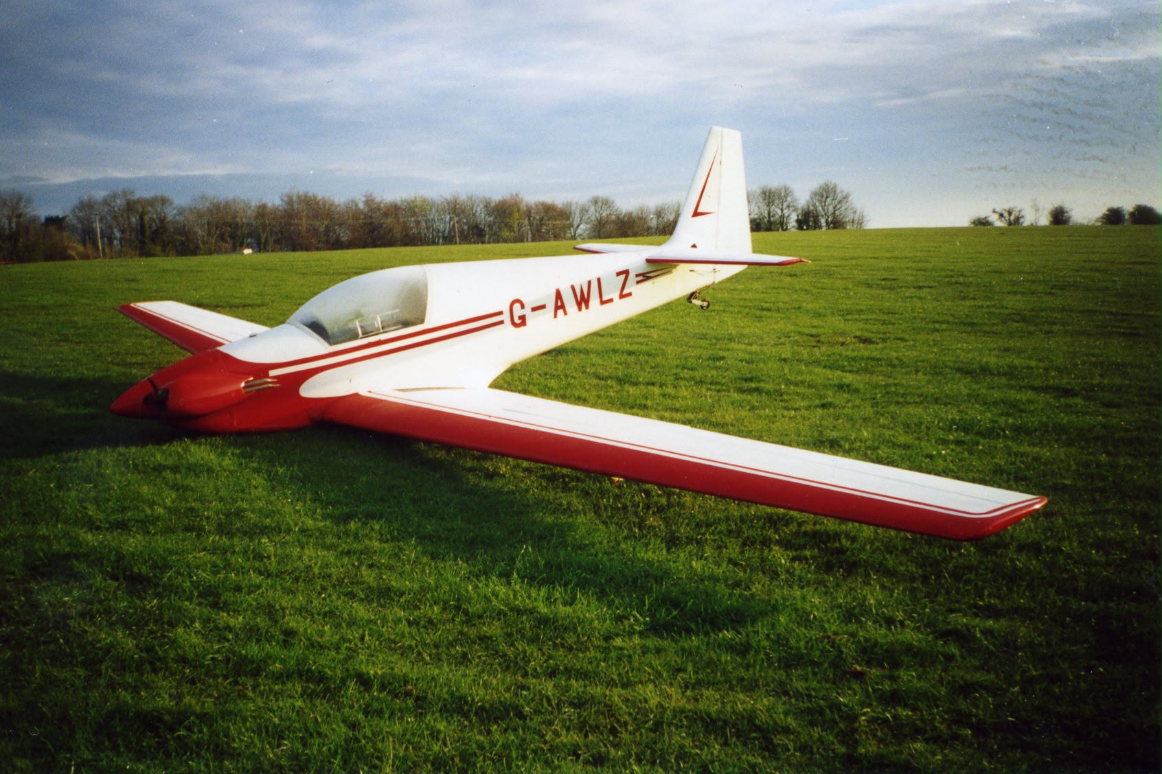 G-AWLZ in an earlier red and white scheme, on the grass