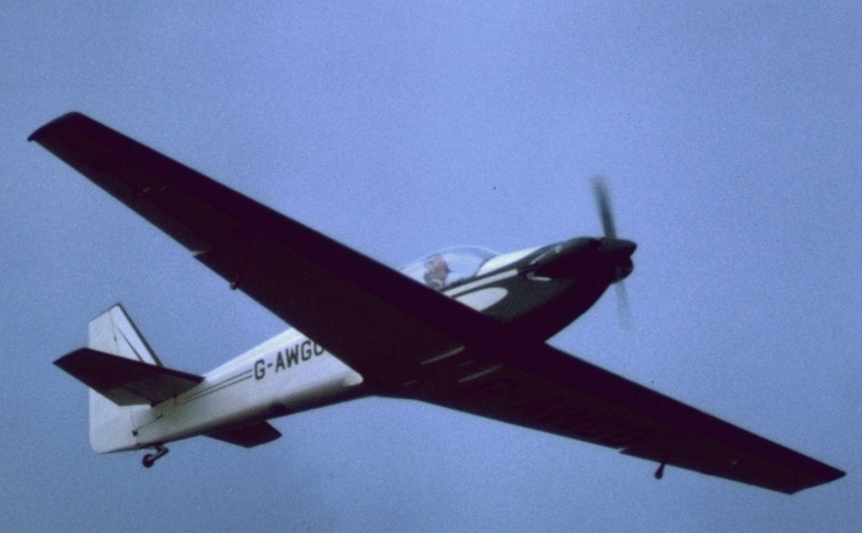 G-AWGO in flight, dark colour scheme, underside view