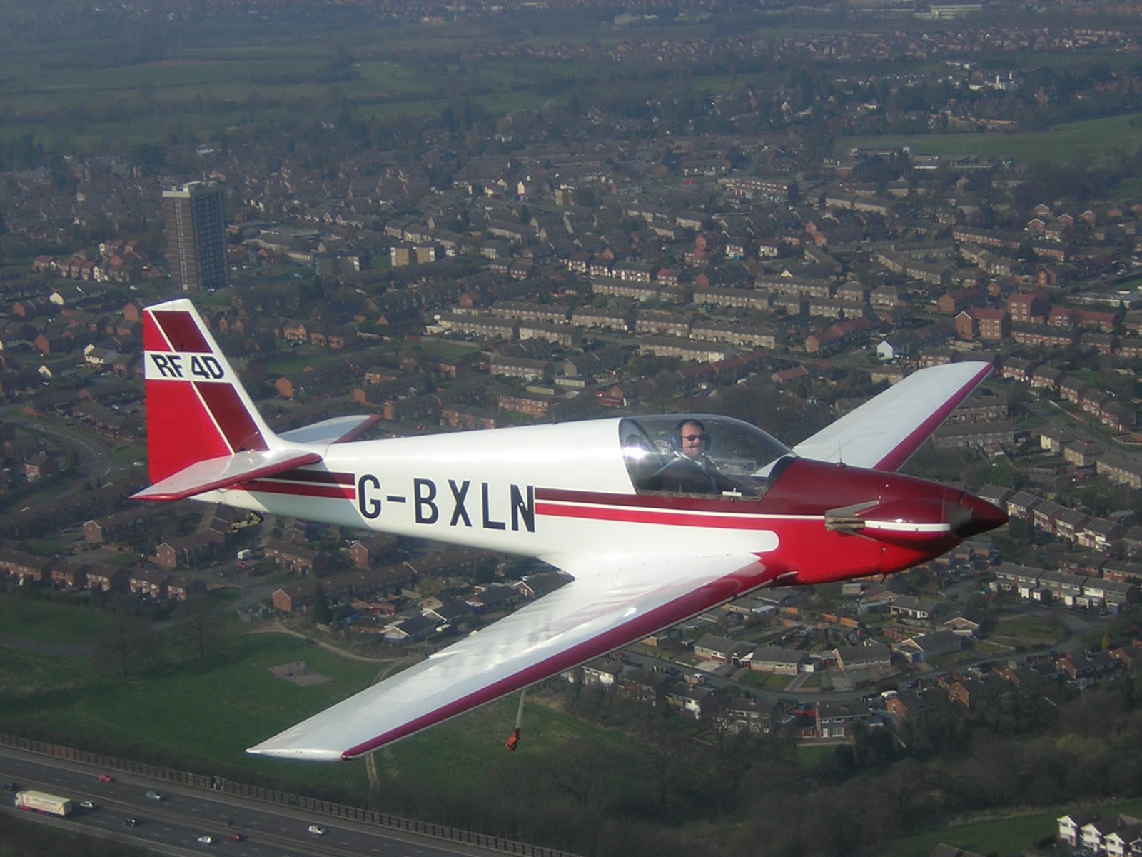 G-BXLN in flight over a town, tail marked RF4D