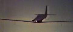 N1700 flying low at dusk near a wire or pole, silhouetted against the sky