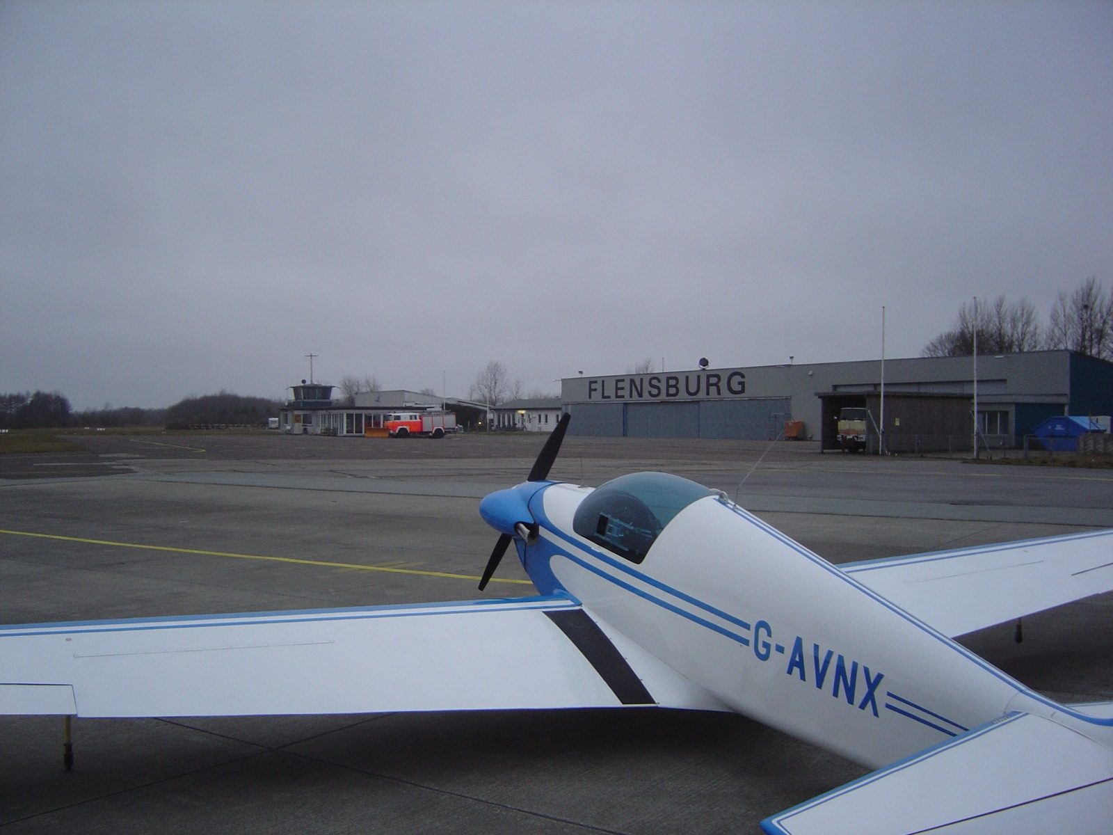 G-AVNX tied down on the apron at Flensburg under grey skies