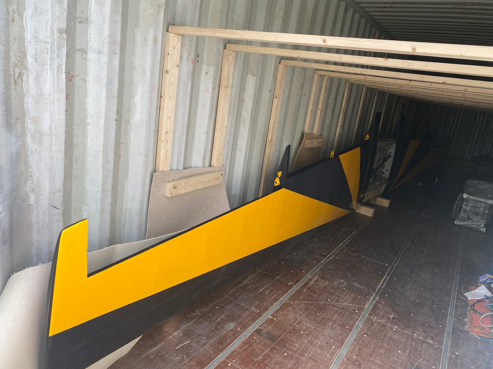 Yellow-tipped black wing panel inside a shipping container