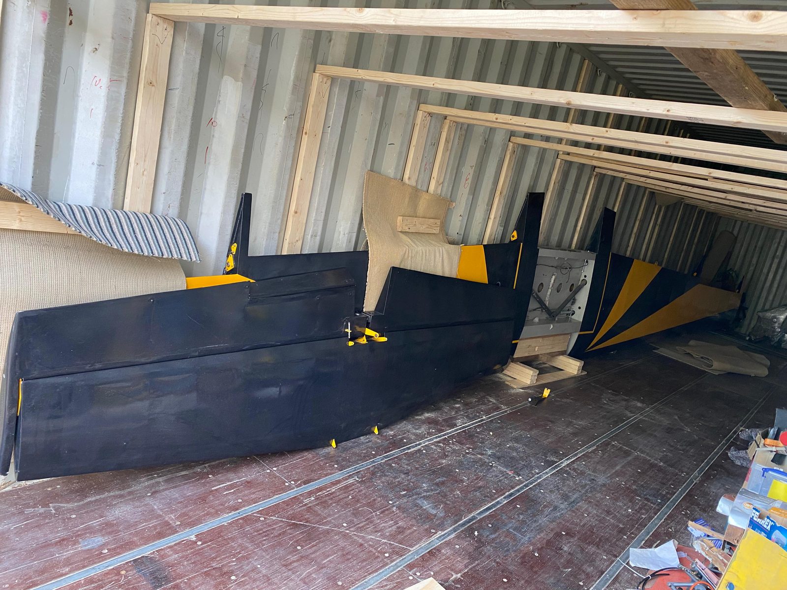 Black and yellow tail surfaces and wing panels in the container